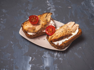 A quick snack of turkey sandwiches, curd cheese and tomatoes.
