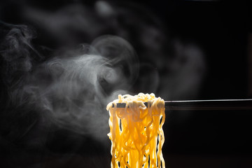 Chopsticks noodles with steam and smoke  on black background. selective focus., korea, japan,...