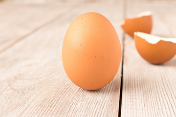 Chicken egg and eggshell on wooden table. Selective focus.