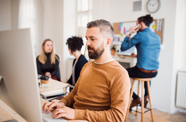 Group of young businesspeople with computer working in a modern office.