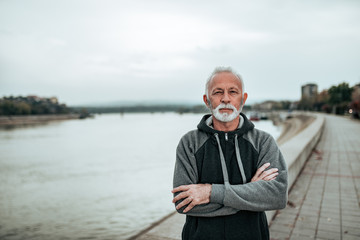 Portrait of a casual senior near the city river.