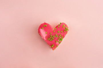 Heart shaped strawberry cake with green decoration on pink background. Heart cake for Valentine's Day