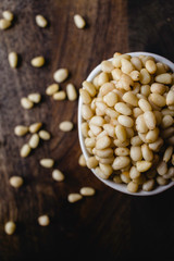 Pine Nuts Raw on Dark Wooden Table. Closeup. Vertical.