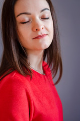 beautiful young slim woman dressed in a bright red dress with a skirt. Poses for a photo in an old-fashioned room with an old decor