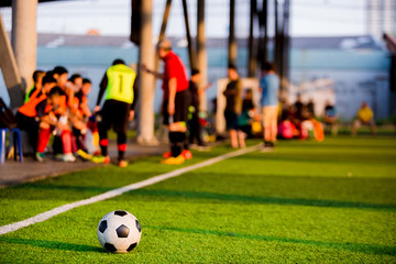 soccer ball at touchlines on artificial turf with blurry of soccer players