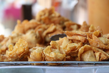 Pile of Fried Crispy Chinese Dumplings on the grill for sale.