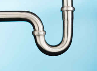 Stainless steel sink pipe on isolated on light blue background