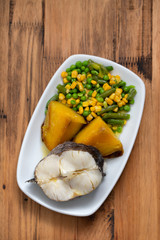 boiled fish with vegetables on white dish