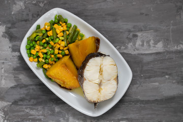 boiled fish with vegetables on white dish