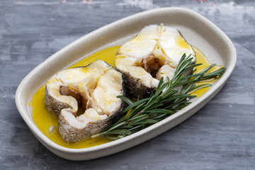 boiled fish with rosemary and olive oil in dish