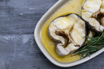 boiled fish with olive oil and rosemary in dish