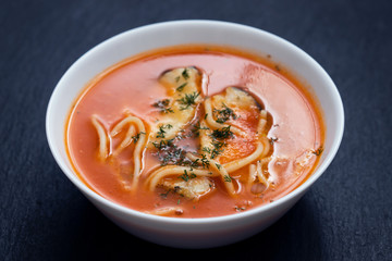 fish soup in the white bowl on ceramic background