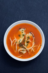 fish soup in the white bowl on ceramic background