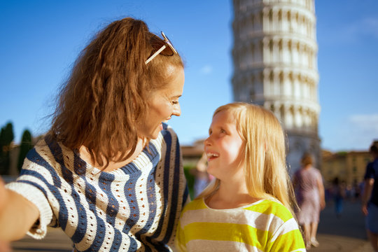 mother and daughter against leaning tower in Pisa taking selfie