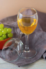 two wine glasses, green grapes on plate on table