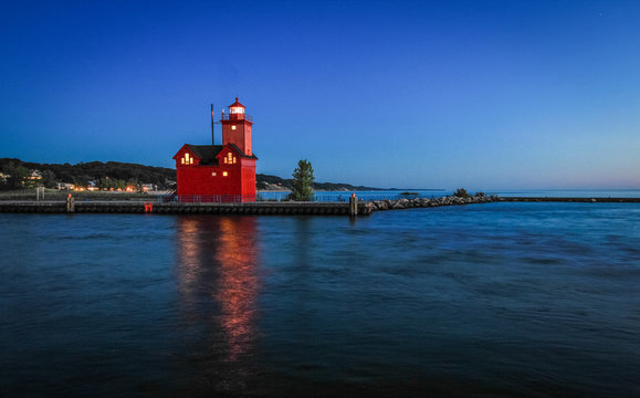 Holland Michigan Lighthouse At Night. The beautiful big red lighthouse at Holland State Park at night with illuminated beacon.