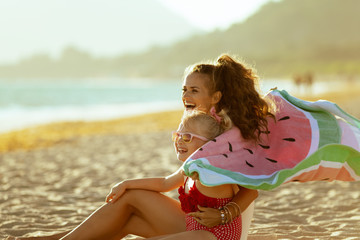 mother and child holding watermelon towel and having fun time