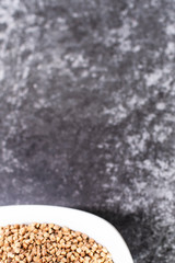 Buckwheat in a plate on the table, background
