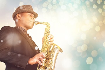 Close-up man playing on saxophone on background