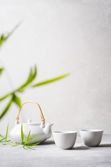 Asian food background set with  green tea, cups and teapot with free space for text on white background.
