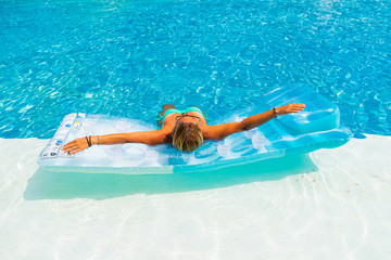 Woman relaxing at the swimming pool at the luxury resort