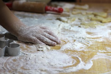 Cooking on kitchen. Having fun together while making cakes and cookies.  Child rolling out dough for christmas cookies.