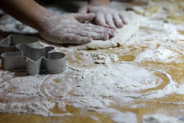 Cooking on kitchen. Having fun together while making cakes and cookies.  Child rolling out dough for christmas cookies.