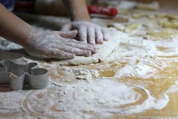 Obraz premium Cooking on kitchen. Having fun together while making cakes and cookies. Child rolling out dough for christmas cookies.