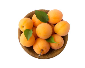 Ripe apricots isolate on a white. Bowl with apricots with leaves isolated on white background. Ripe apricots with copy space for text. Fruit on white background.Top view.