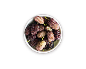Mulberries in a bowl with copy space for text. Black and purple mulberry on white background. Ripe and tasty mulberry isolated on white background. Top view.