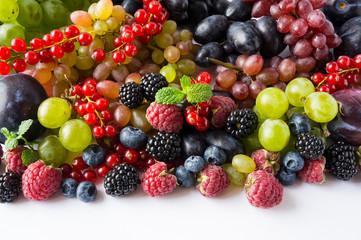 Mix berries on a white background. Ripe red currants, grapes, blackberries, blueberries and raspberries on white background. Top view. Fruits with copy space for text. Black-blue and red food.
