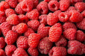 Background of raspberries. Fresh raspberries closeup. Top view. Background of red berries. Various fresh summer fruits. Red raspberries. Red food.
