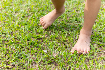 Baby's foot stepping on the grass.