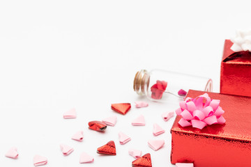  Red gift box with a glass jar with flowers inside Decorated with hearts folded from red and pink paper For Valentine's Day With a white background.