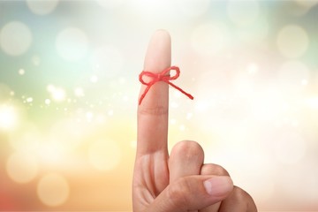 Rope bow on finger pointing on light background