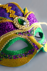 Jester mask with large gem.  Portrait crop with grey background.  Object only.  No people.