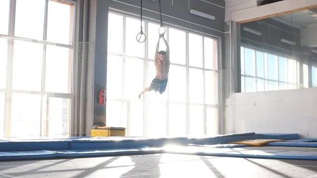 Young sporty man jumping and flying on trampoline in fly park. slow motion