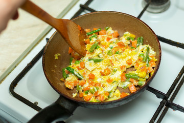frying eggs with a mixture of vegetables for breakfast