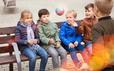 Children playing with ball on bench