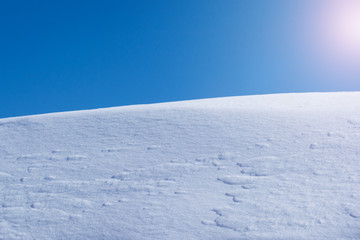 Fototapeta na wymiar A heap of snow against the blue sky