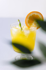 Tasty Orange Juice in Glass With Ice Cube Blue and White Background Fresh Oranges Vertical