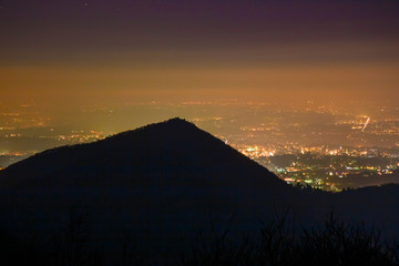 Panoramic night view from above, of the city lights, with low polluted atmospheric layers.