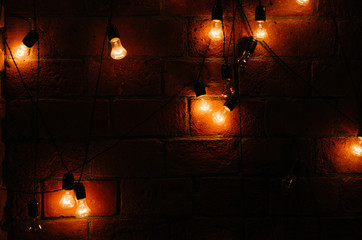 yellow light bulbs with black wires on a brick wall