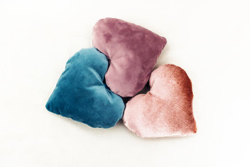 Three heart shaped pillows made up from velvet