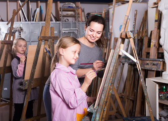 Woman teacher assisting student during painting class