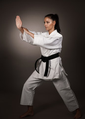 Woman in white  kimono punch hard in the air -  a karate martial art girl