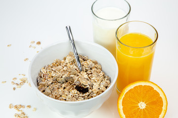 Balanced breakfast with muesli bowl, milk and fresh orange juice