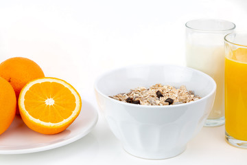 Balanced breakfast with muesli bowl, milk and fresh orange juice