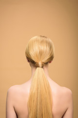 Naklejka premium back view of naked blonde girl with long straight hair isolated on beige