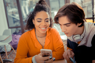 Girl showing photos from vacations to her friend